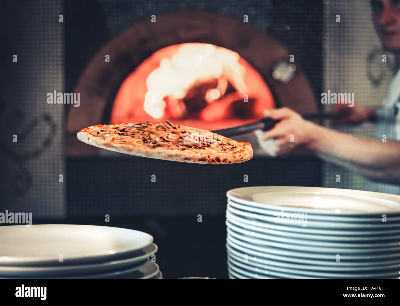 male cook pulls out the finished pizza Stock Photo