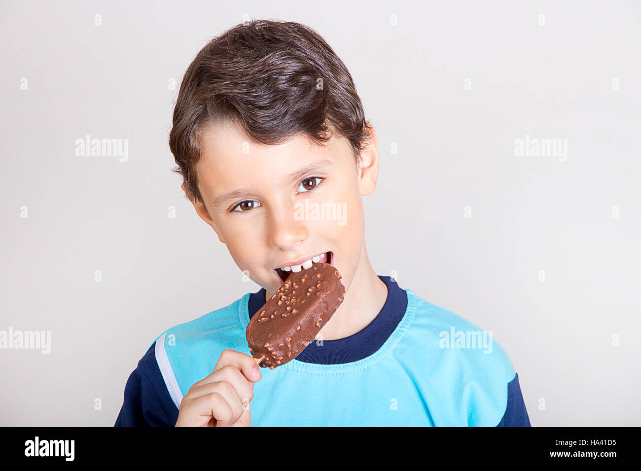 Young kid feeling happy while eating chocolate ice cream bar Stock Photo
