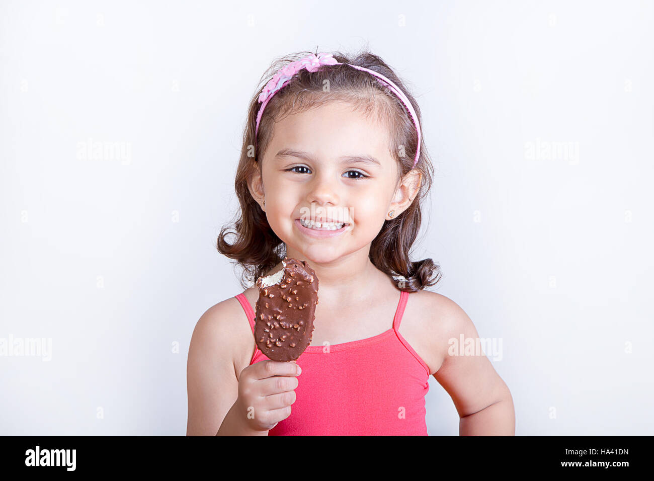 Young girl feeling happy while eating chocolate ice cream bar Stock Photo