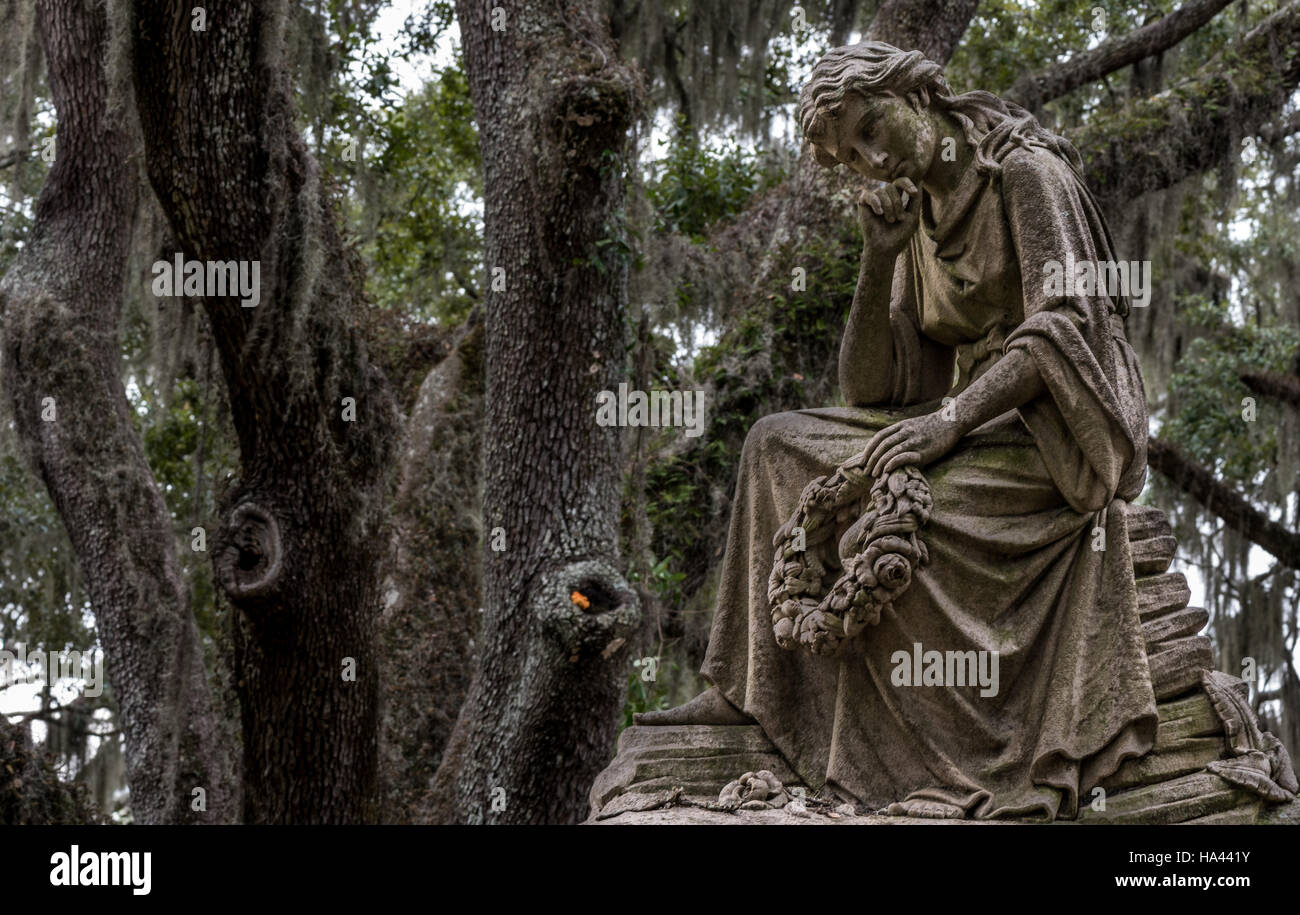 Thinking Woman Holding Wreath Close with live oak tree and Spanish moss in background Stock Photo