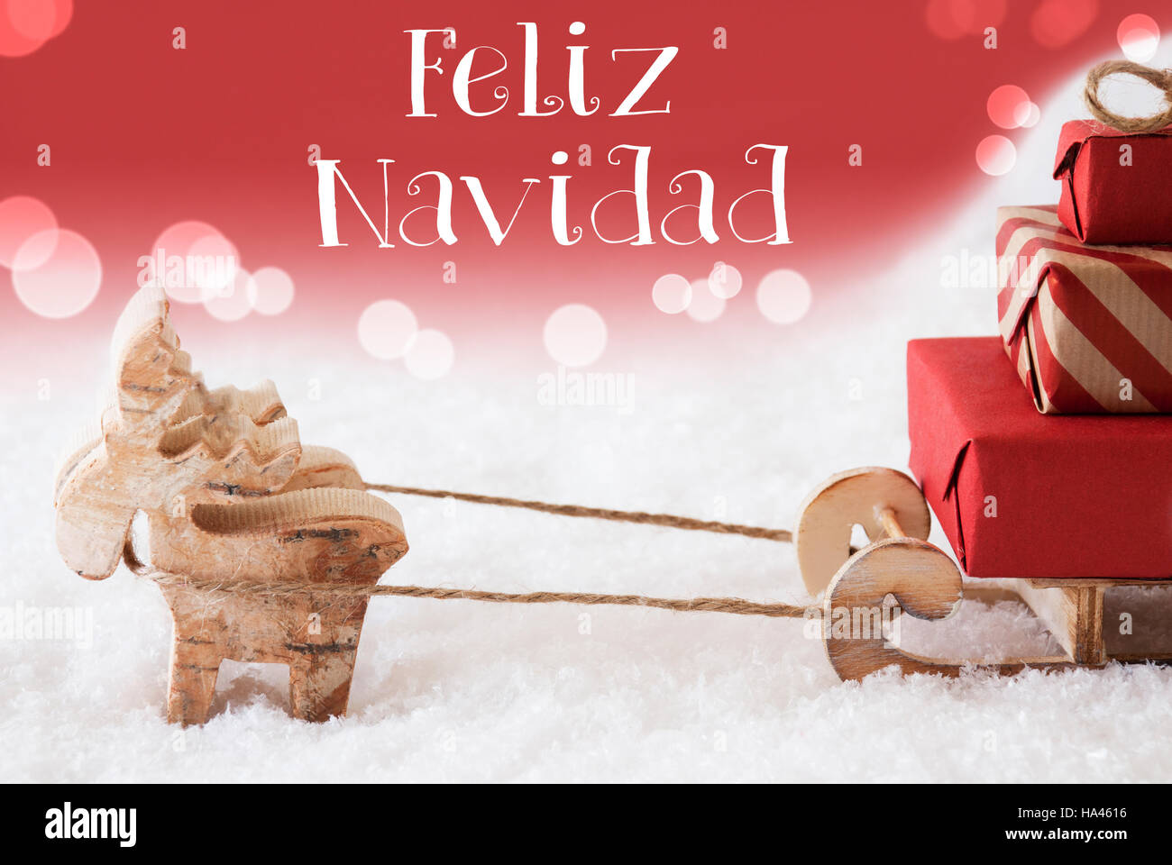 Reindeer With Sled, Red Background, Feliz Navidad Means Merry Christmas Stock Photo
