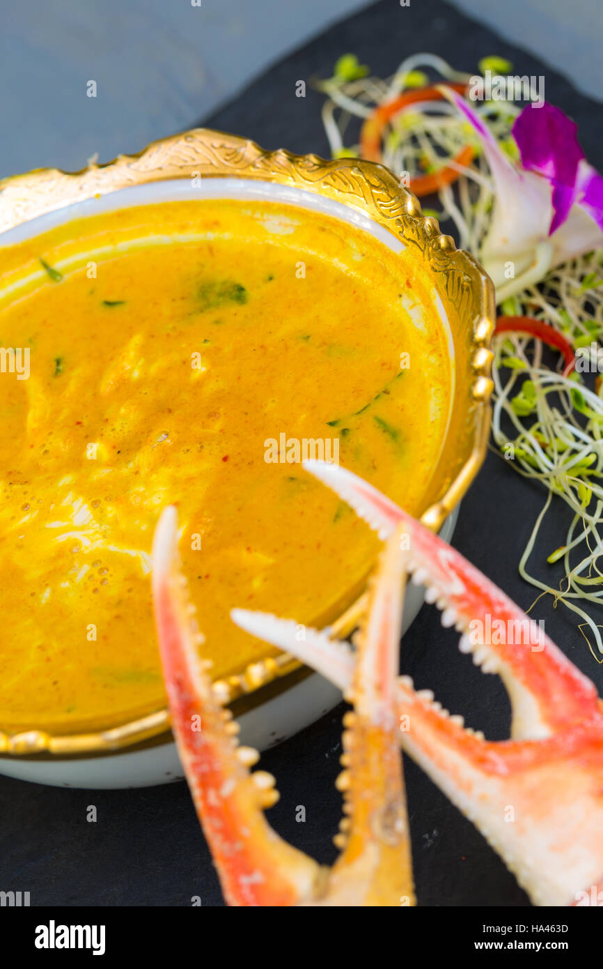 Bowl of yellow crab curry soup with two crab claws Stock Photo - Alamy