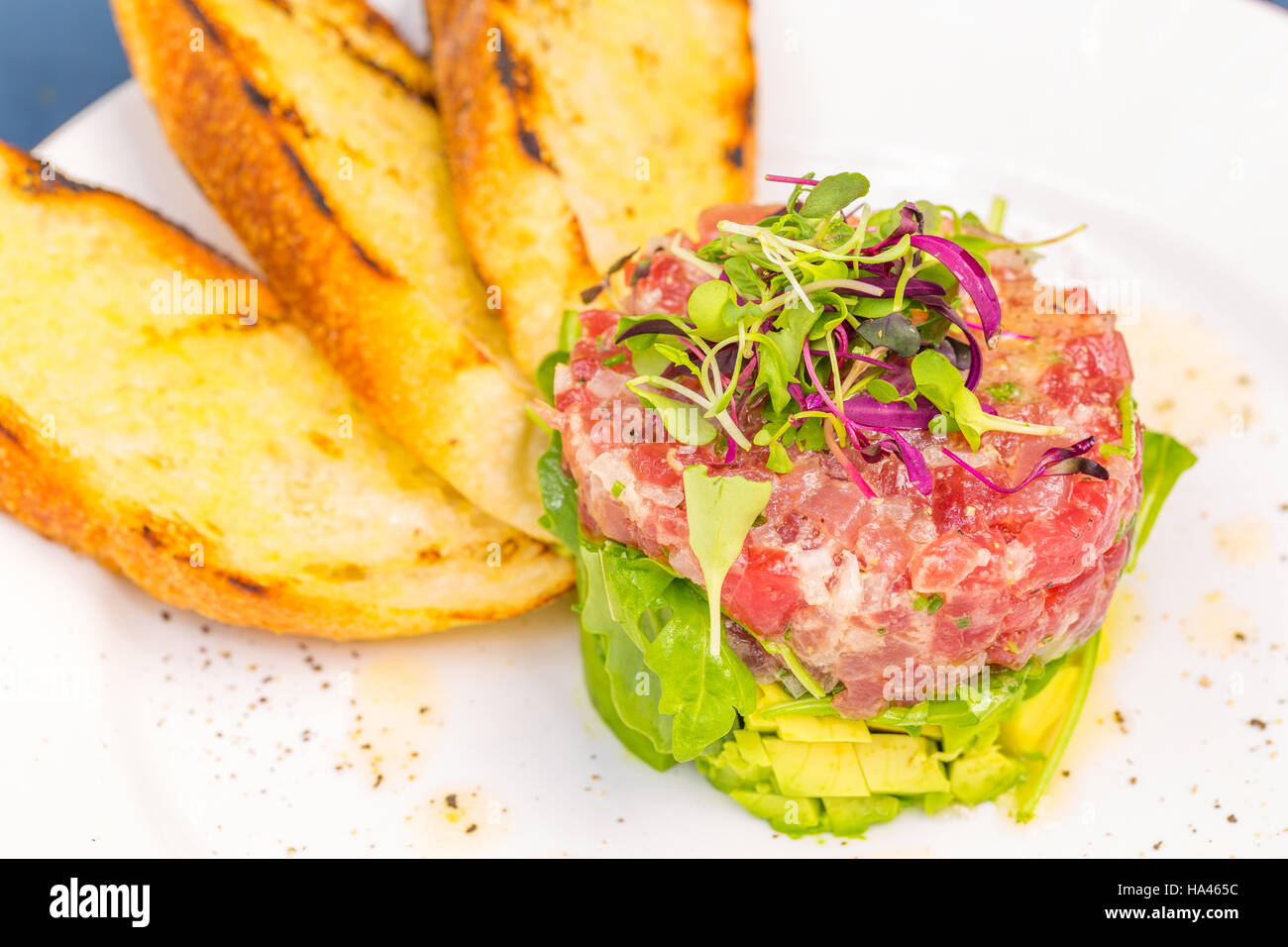 Ahi tuna tartare stacked with avocado, arugula, topped with micro
