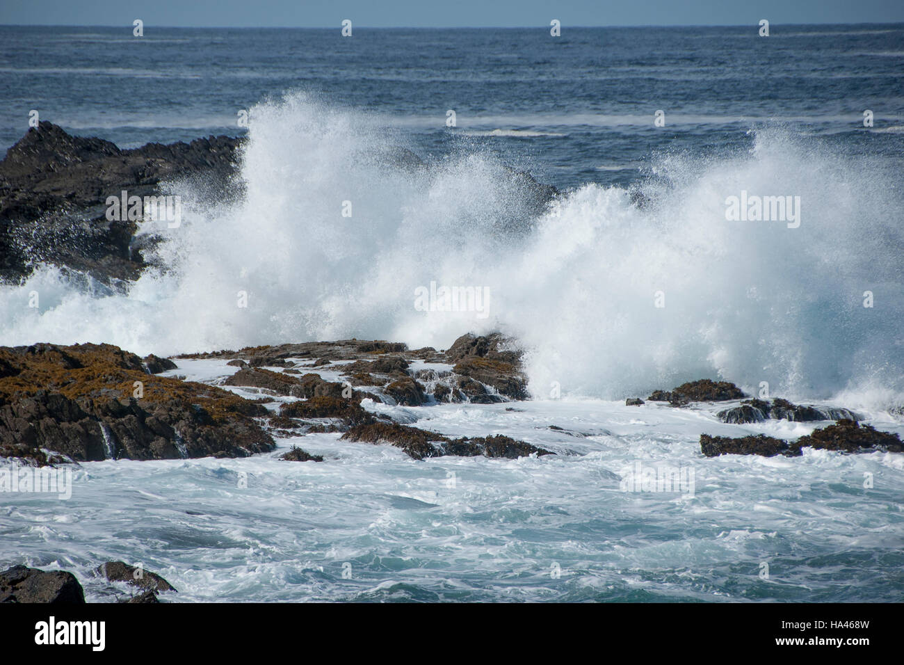 Huge white waves crashing against the rocks Stock Photo