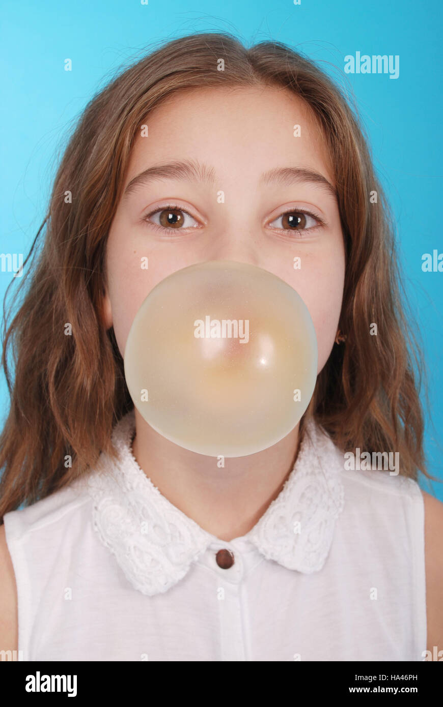 Girl blowing a big bubble gum bubble isolated on blue Stock Photo Alamy