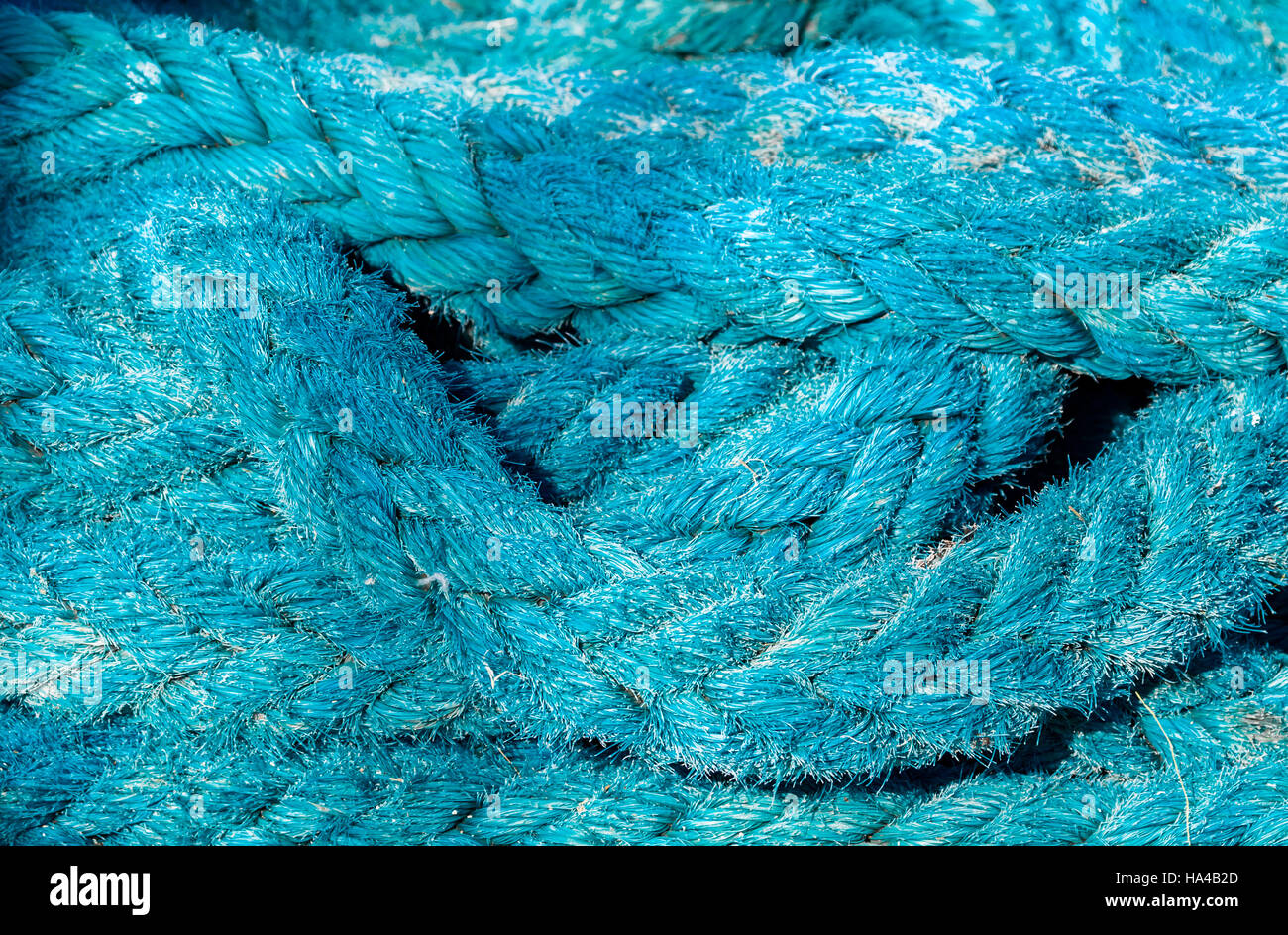 Detail of a heavy blue nylon rope used to attach a boat to a plying Stock Photo