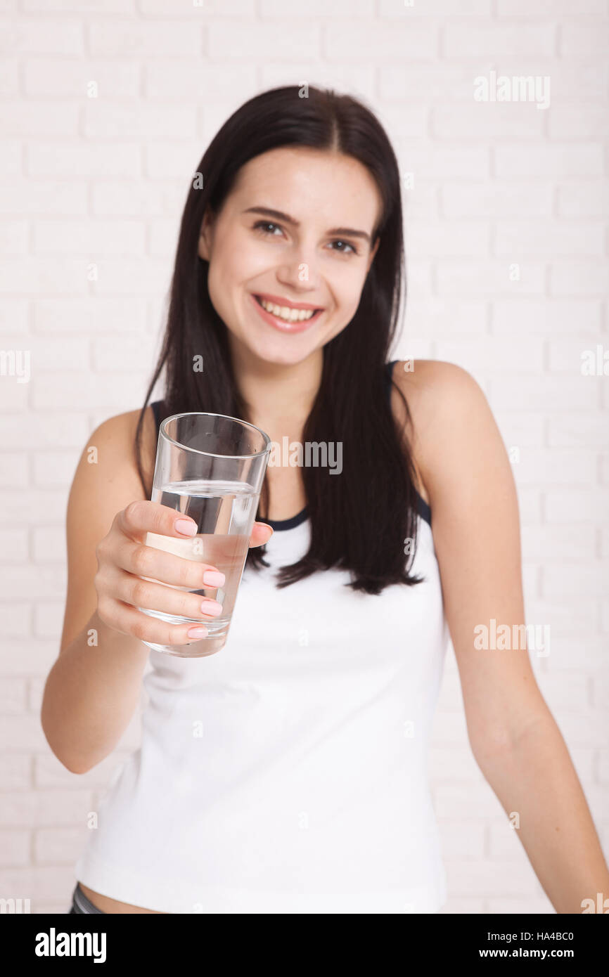 Girl drinking water at home. Glass of water in morning before breakfast. Selective focus Stock