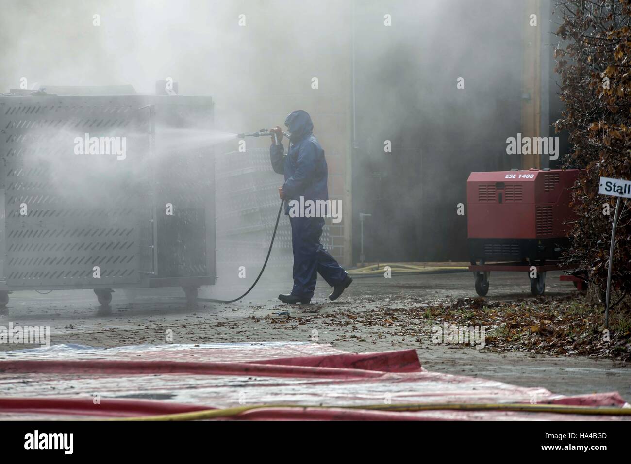 Barssel, Germany. 26th Nov, 2016. A man disinfects the Aurelia-G machine for barn fumigation on the grounds of a farm in Barssel, Germany, 26 November 2016. The highly-contagious bird flu virus H5N8 was detected at the site on 23.11.2016. Photo: Lars Klemmer/dpa/Alamy Live News Stock Photo