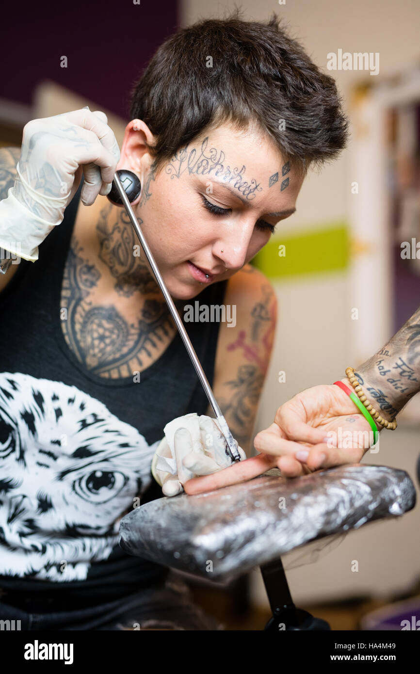 Grafing, Germany. 16th Nov, 2016. Tattoo artist Georgina Ostheimer works on a tattoo on the finger of a man with the special bamboo technique in Grafing, Germany, 16 November 2016. The 33-year-old Grafing, Germany. 16th Nov, 2016. Tattoo artist Georgina Ostheimer works on a tattoo on the finger of a man with the special bamboo technique in Grafing, Germany, 16 November 2016. The 33-year-old