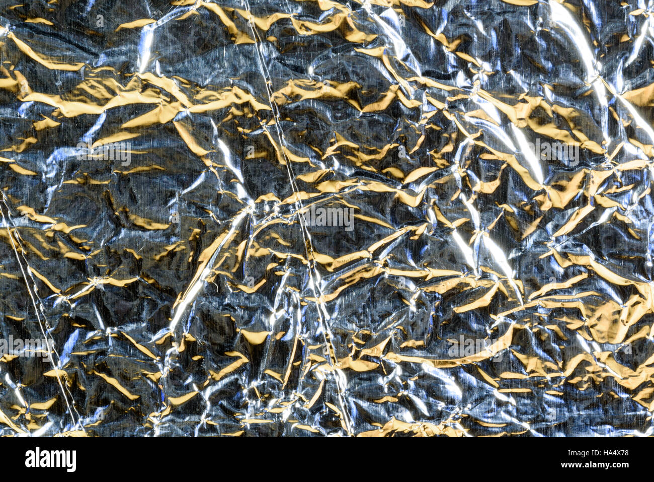 Crumpled Aluminum tin foil texture with light reflections on the shiny metallic silver wrapping Stock Photo