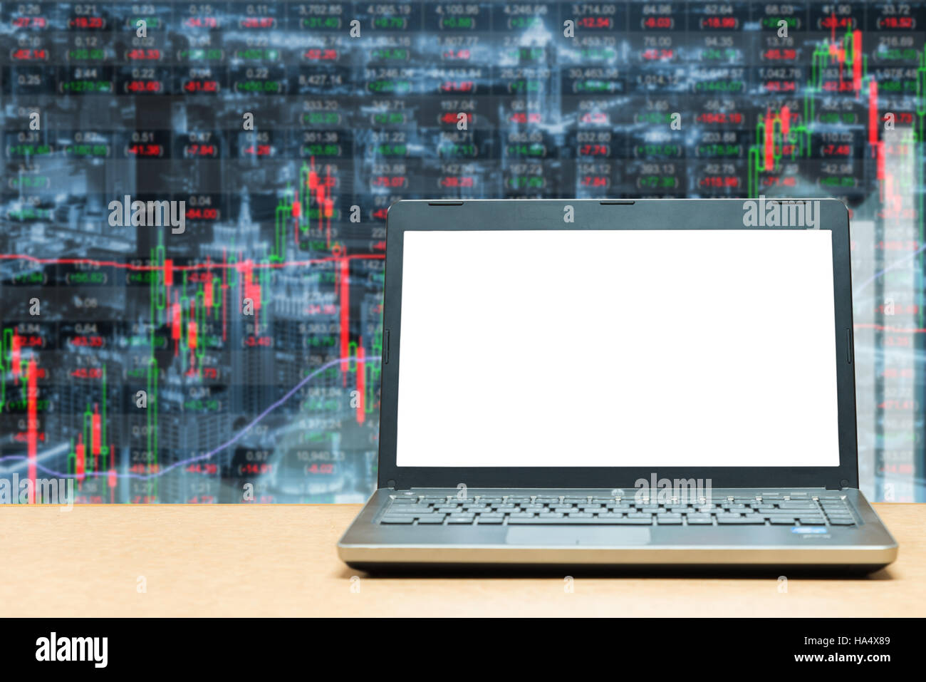 Laptop with blank screen on table with stock exchange market business trading graph. Business marketing trade concept. Stock Photo