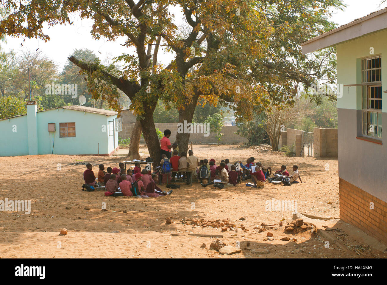 Children at Chintimba Primary School holding class outside due to lack of classroom space in Victoria Falls, Zimbabwe Stock Photo