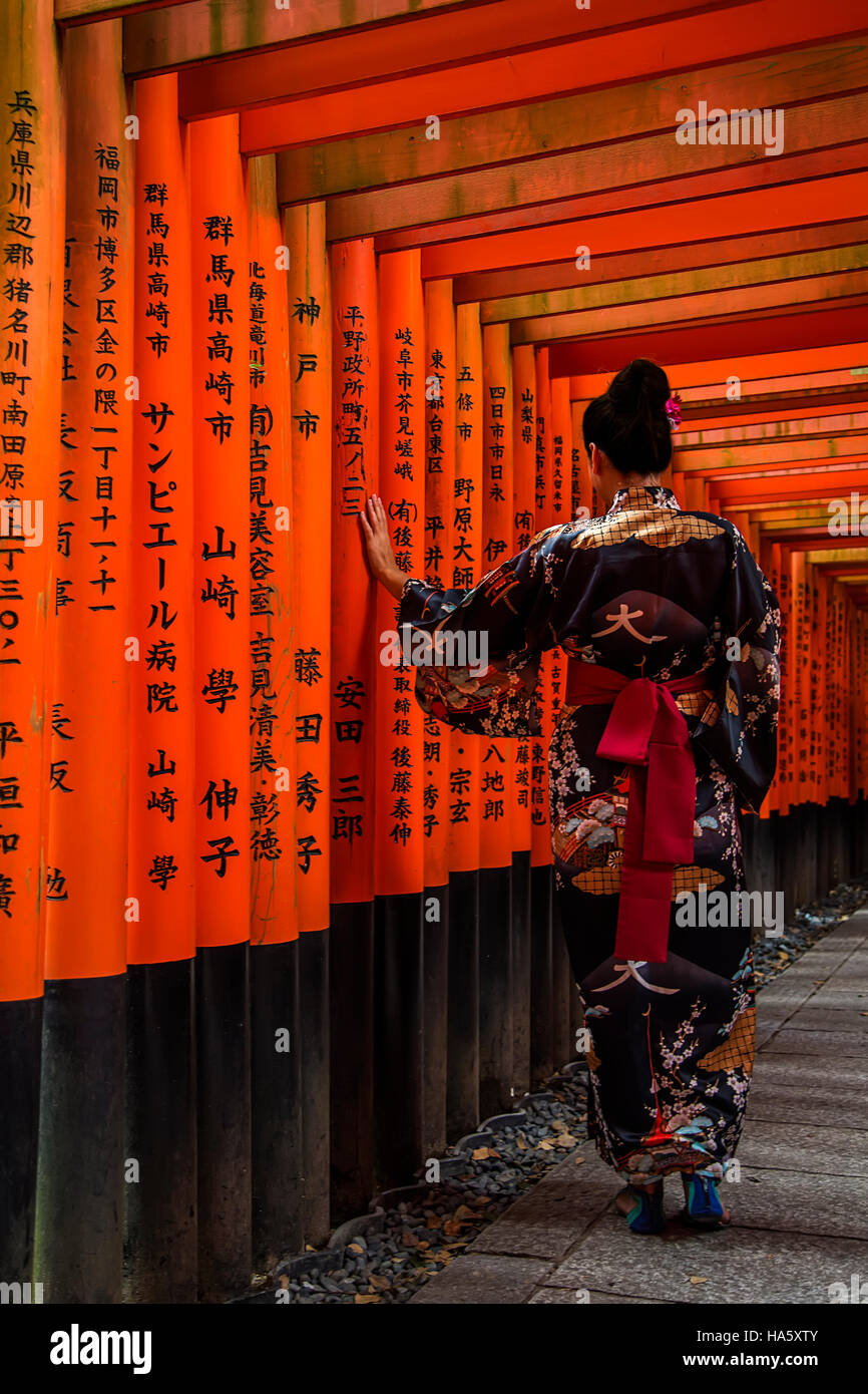 Unidentified woman at walkway in Fushimi Inari shrine in Kyoto, Japan. Stock Photo