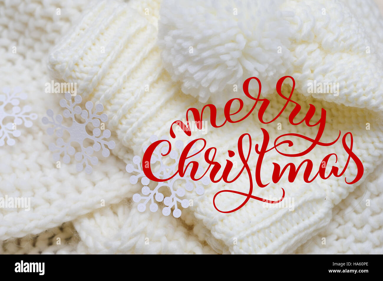 White knit scarf and hat for background with text Merry Christmas. Calligraphy lettering Stock Photo