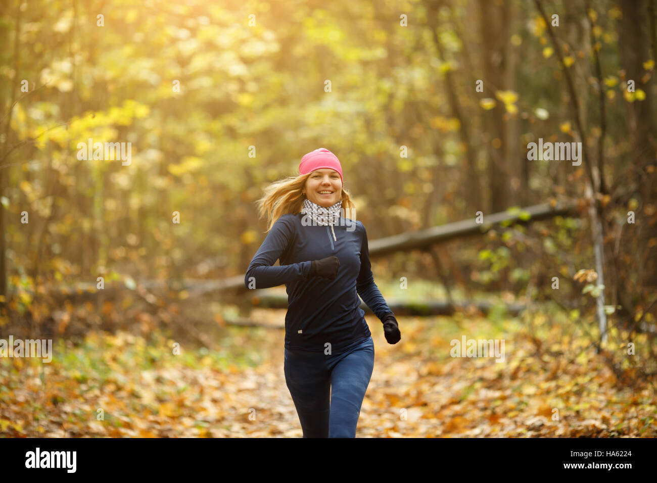 Blonde woman jogging in morning in autumn park Stock Photo - Alamy