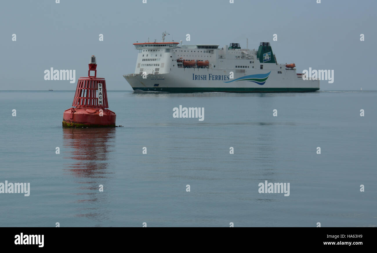 The Isle of Inishmore Irish ferry passes Stack Rock Port lateral navigation buoy on a glassy summer sea. Stock Photo