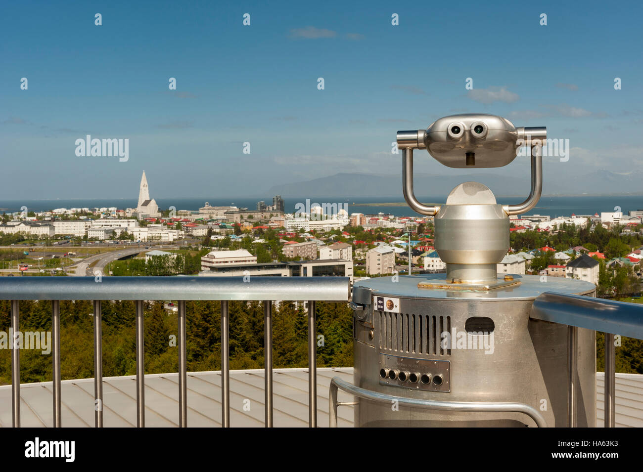 A coin-operated viewer pointed to downtown Reykjavik, Iceland, from the Perlan viewing deck, with Hallgrimskirkja in the frame. Stock Photo