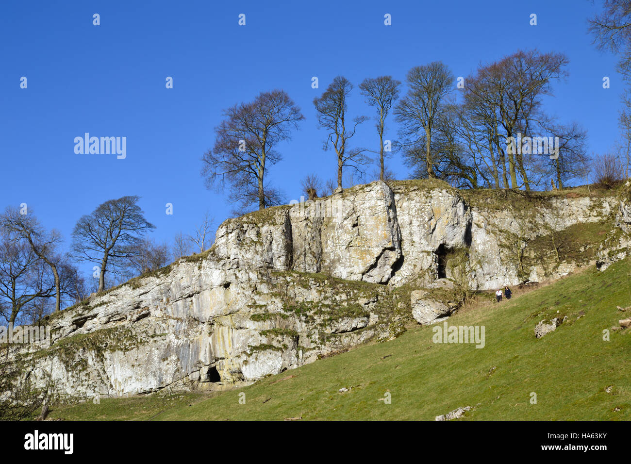 The caves and limestone cliffs of Wolfscote Dale beside the River Dove Stock Photo