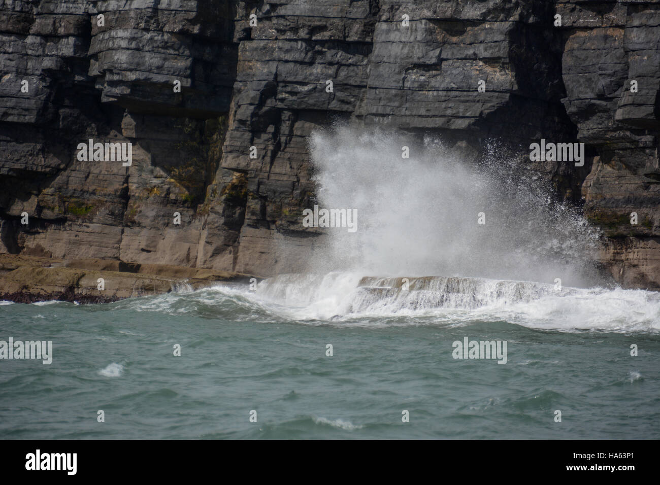 Waves crashing against cliffs on Pembrokeshire coast Stock Photo