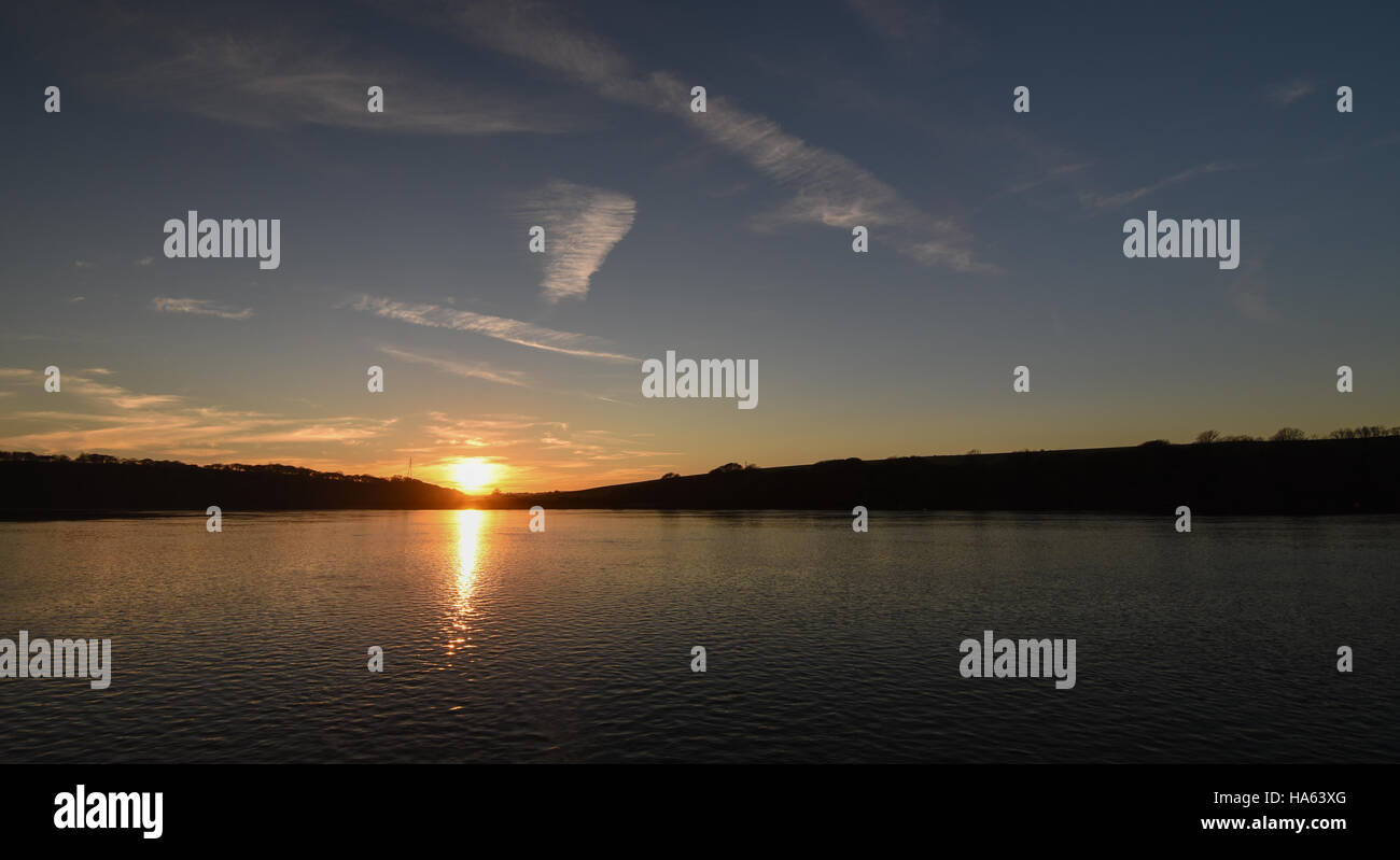 Golden sunset, blue sky and clouds reflected in perfectly calm water Stock Photo