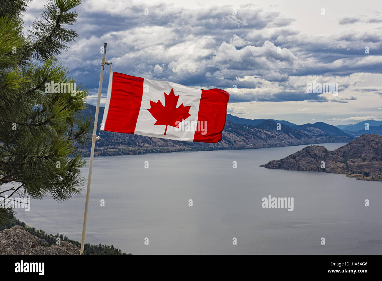 Canadian Flag flies over Okanagan Lake near Peachland British Columbia Canada on a windy day Stock Photo