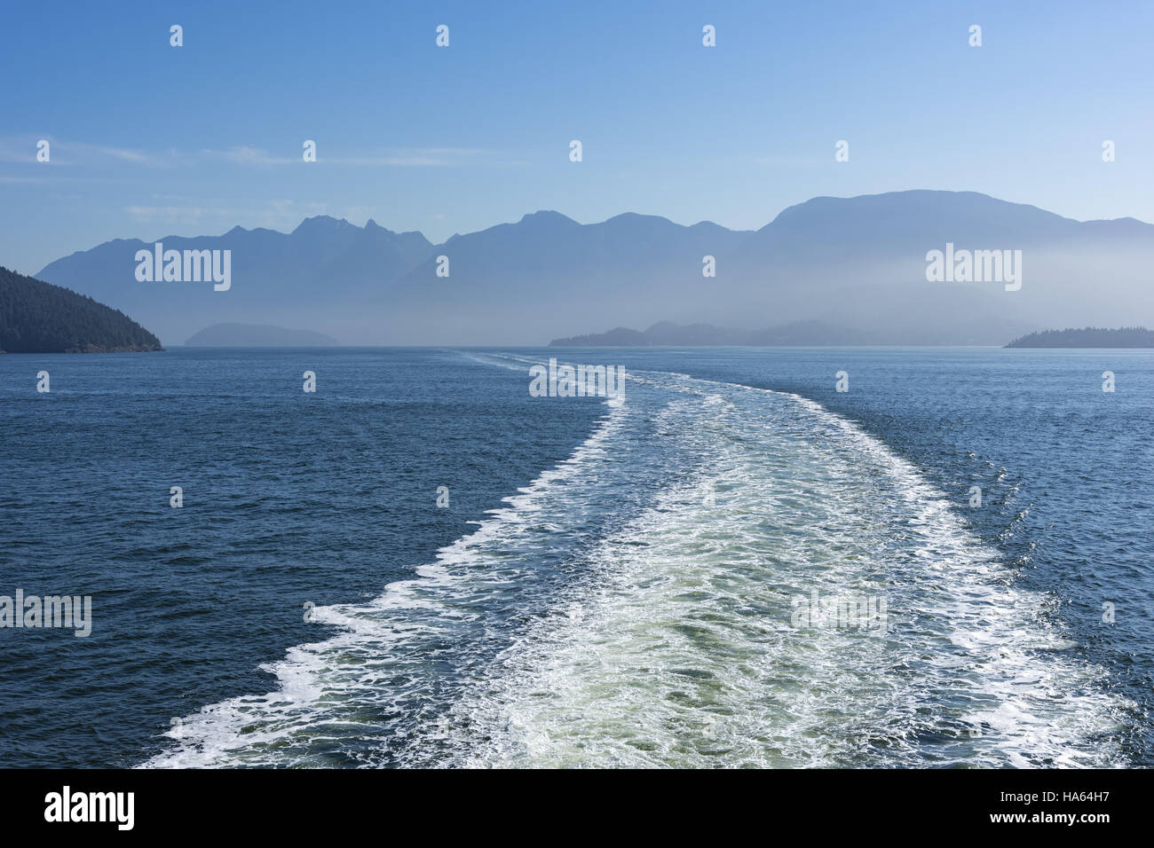 Wake of a Ferry near Vancouver Island with mountains in the background Stock Photo