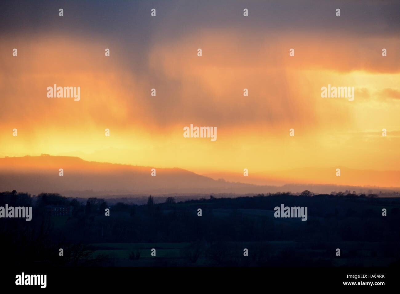 The moment rain started to fall on Cotswold hills at sunset Stock Photo