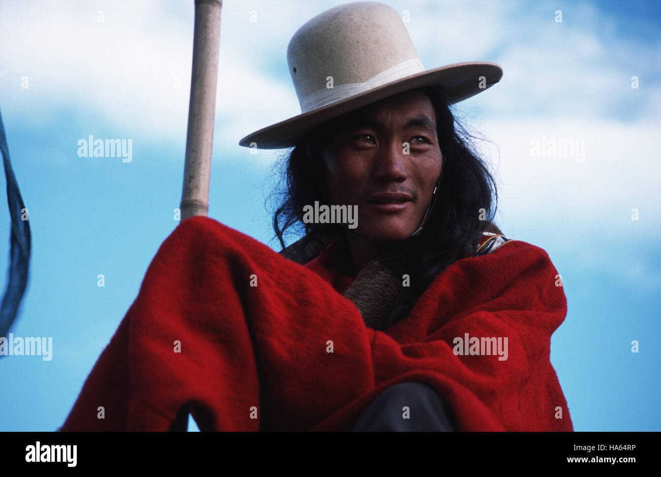 Caption: Ser'xu, Sichuan, China - Aug 2002. A Khampa man carrying the flag of his home tribe waits to ride in the open ceremony of the Ser'xu Horserac Stock Photo