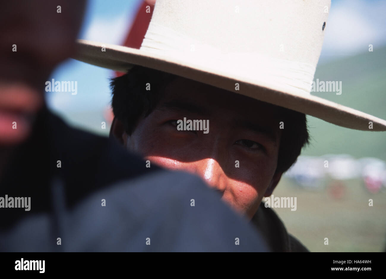 Caption: Ser'xu, Sichuan, China - Aug 2002. An ethnic Khampa man watching the horse races at the Ser'xu Horseracing festival in eastern Tibet.The hors Stock Photo