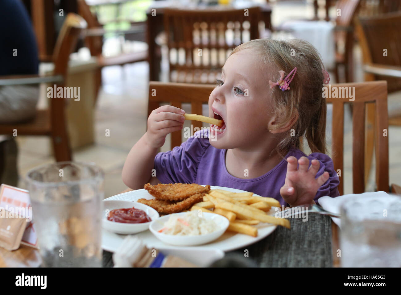 Girl eating French fries. Stock Photo