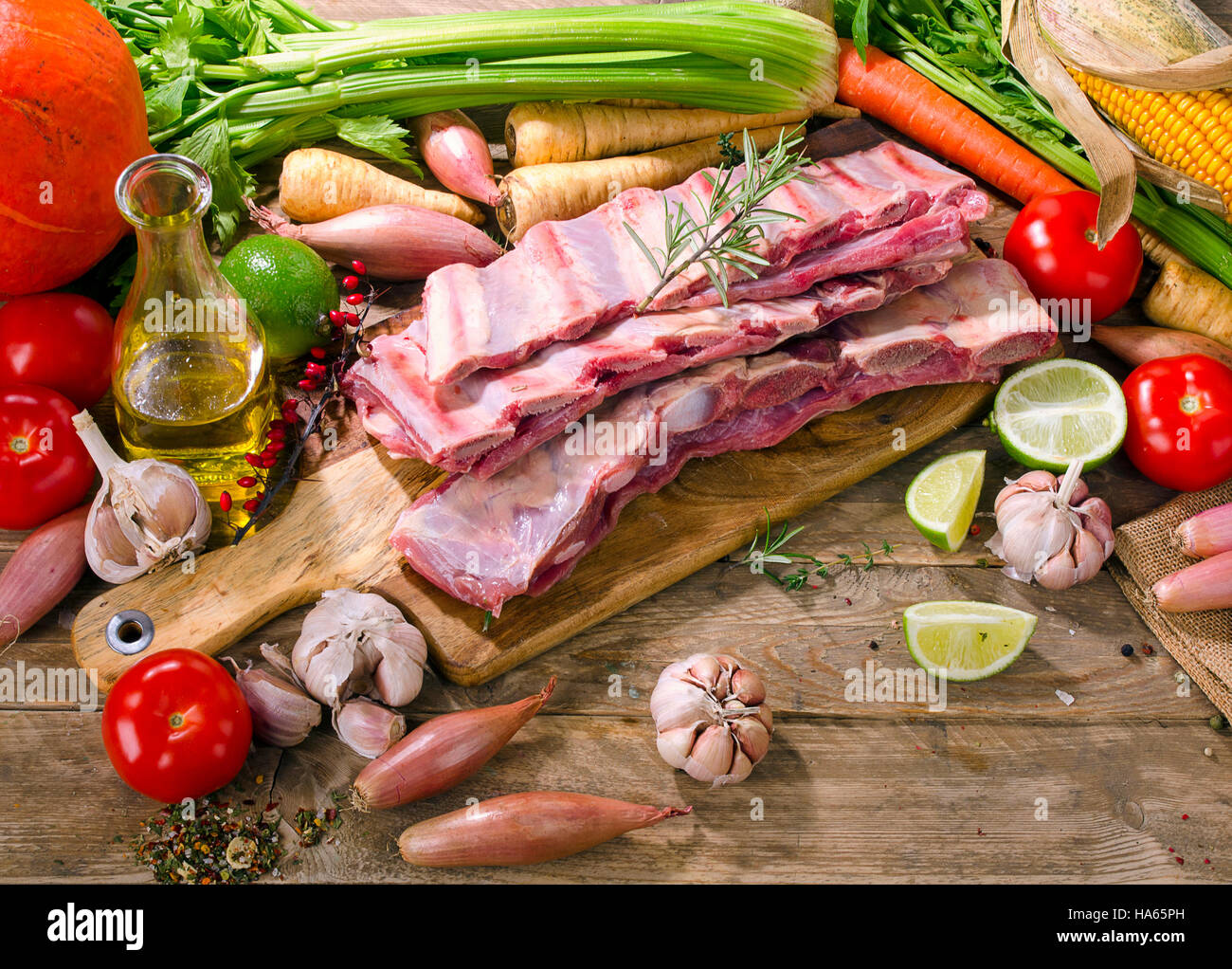 Raw beef ribs and vegetables on  wooden board. Stock Photo
