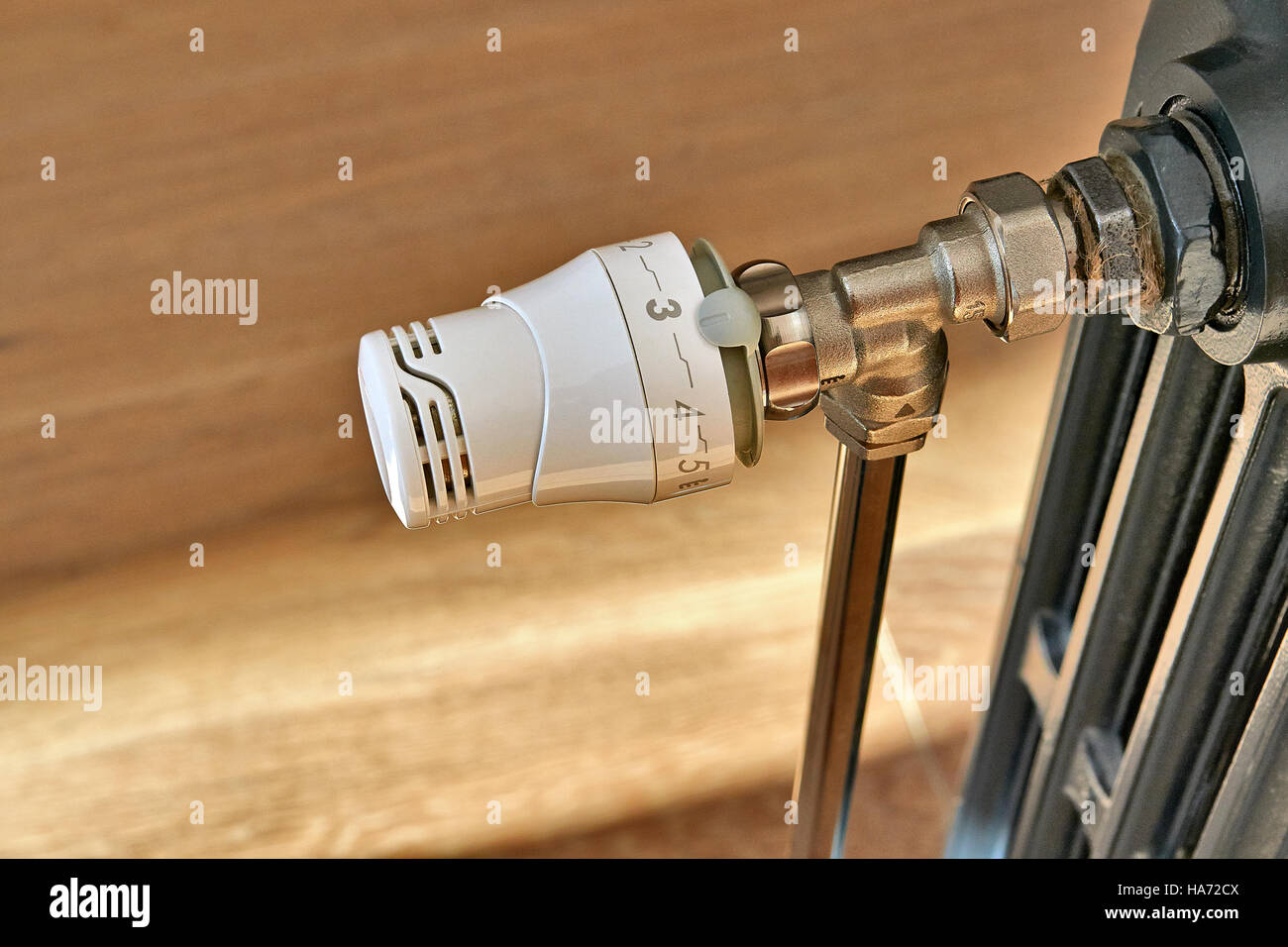 New valve on a old radiator in domestic room Stock Photo
