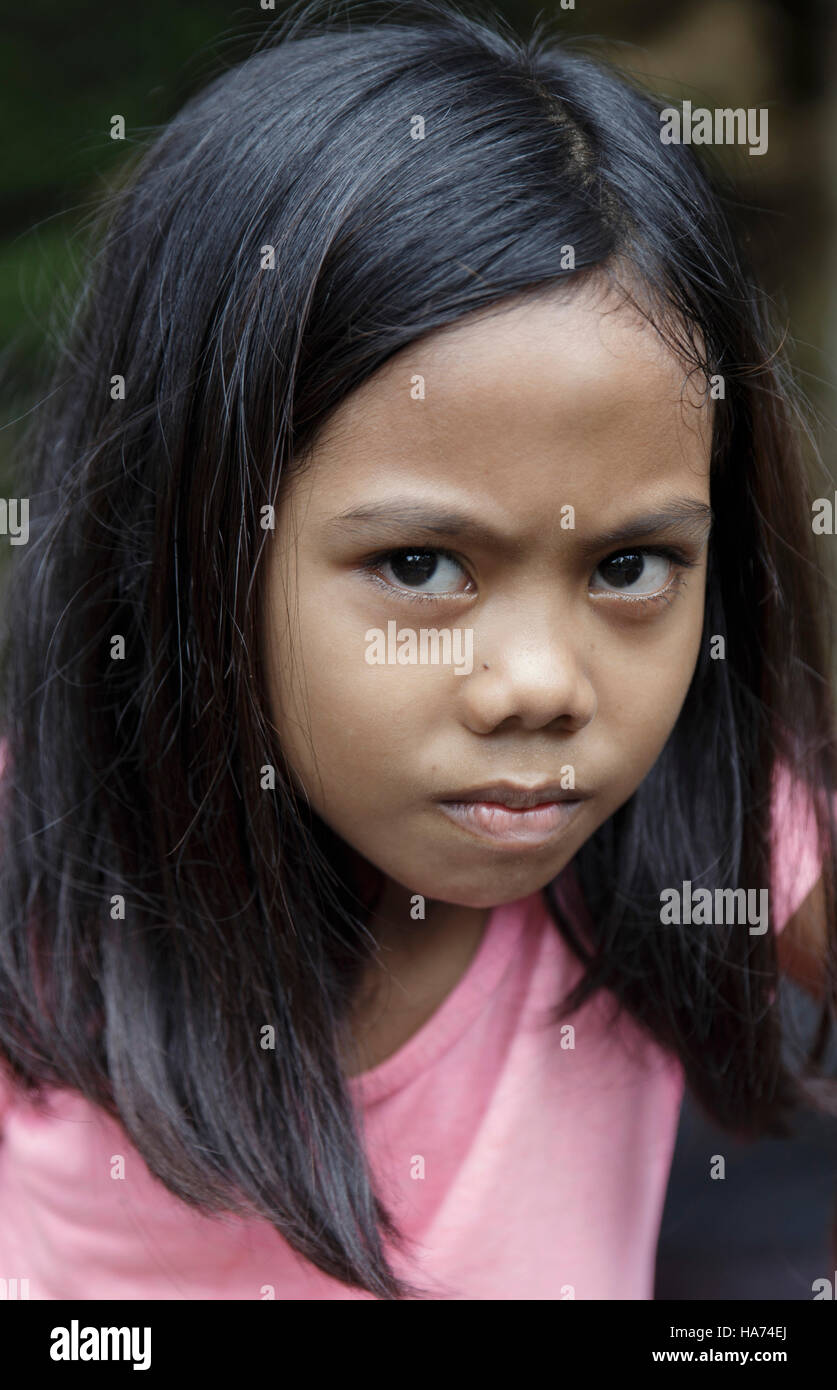 SIPALAY,PHILIPPINES-OCTOBER 13,2016: Filipina girl plays in the street after leaving school on October 13, Sipalay,Philippines. Stock Photo