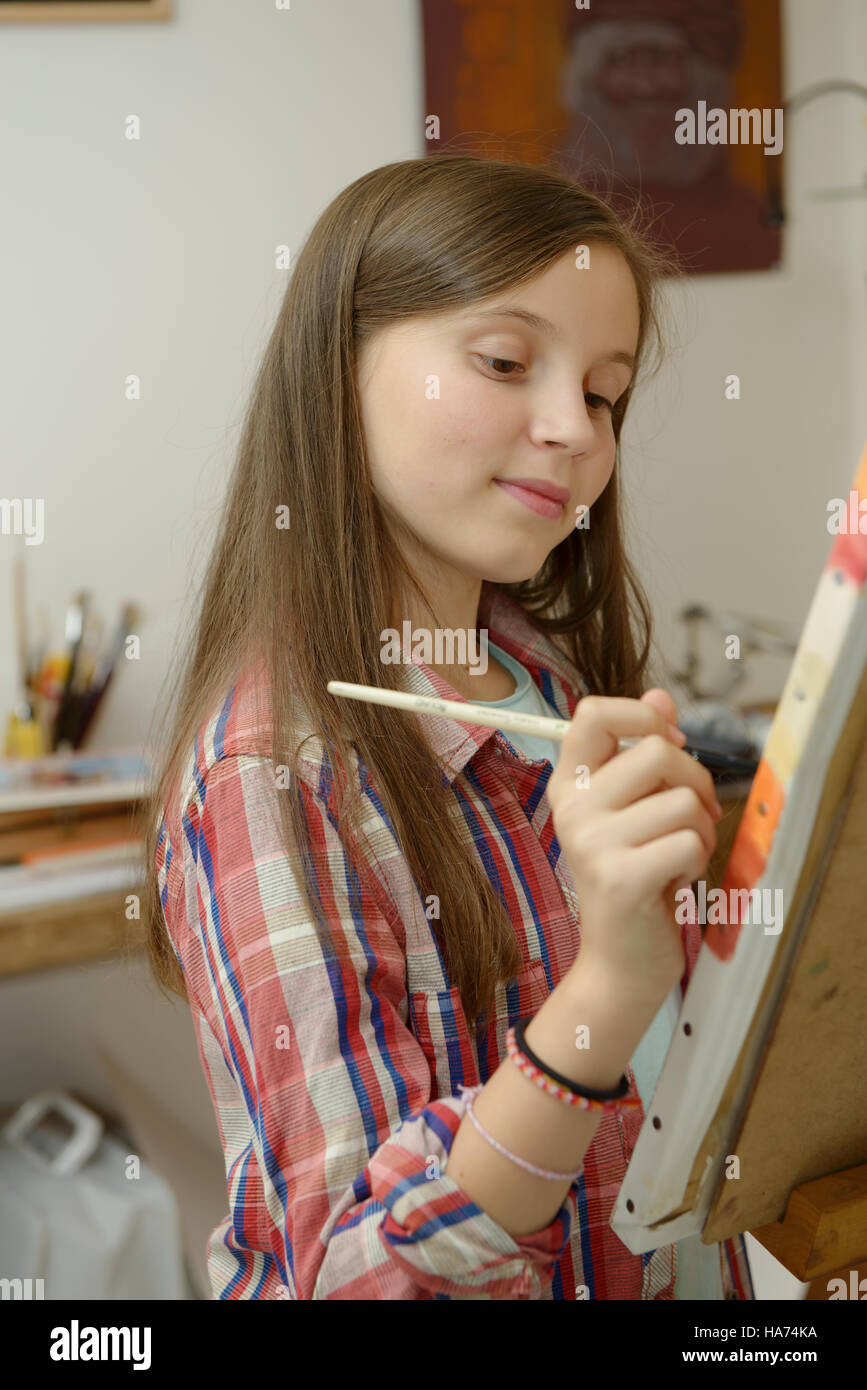 Smiling young artist girl teen painting a canvas Stock Photo Alamy