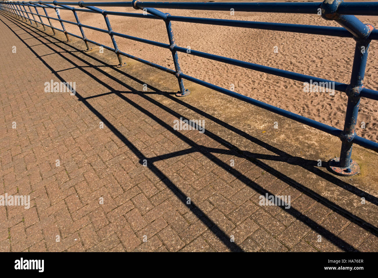 Perspective view of promenade railings with shadows in Spittal, Northumberland Stock Photo