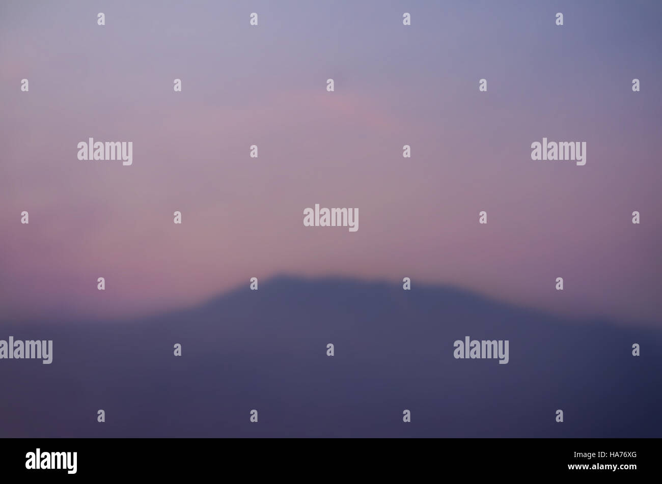 Blurred landscape of mountains with colored sky at sunset or sunrise Stock Photo
