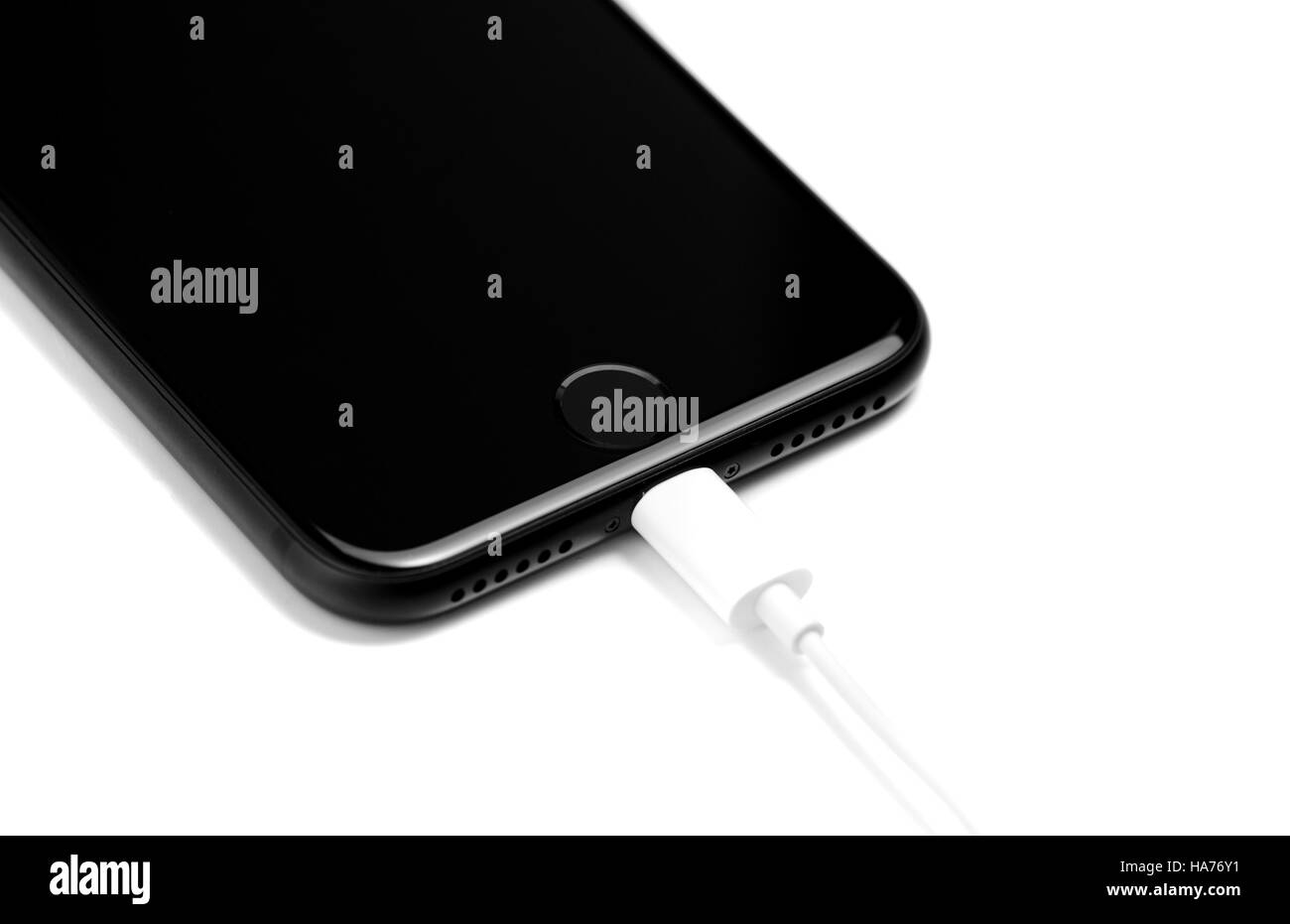 BRASOV, ROMANIA - 25 November 2016: iPhone 7 black matte new Apple product charging; detail of lightning cable and stereo speaker isolated on white Stock Photo