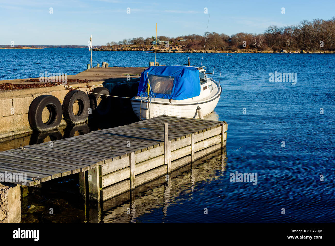Tjurko, Sweden - November 24, 2016: Travel documentary of small local marina in fall. One motorboat moored dockside and the archipelago visible in the Stock Photo