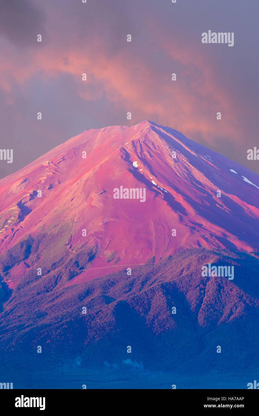 Beautiful pink sky lights up the red volcanic cone top of Mount Fuji in detail telephoto view on a summer morning in Kawaguchiko Stock Photo