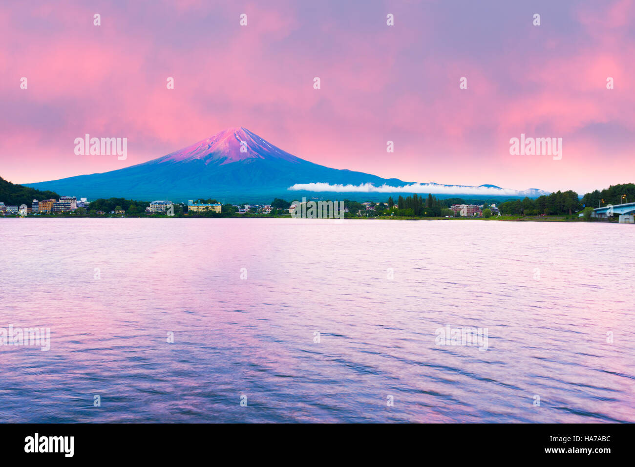 Fiery colorful sky above the red crater cone of Mount Fuji at dawn sunrise over Lake Kawaguchiko water on summer morning, Japan Stock Photo