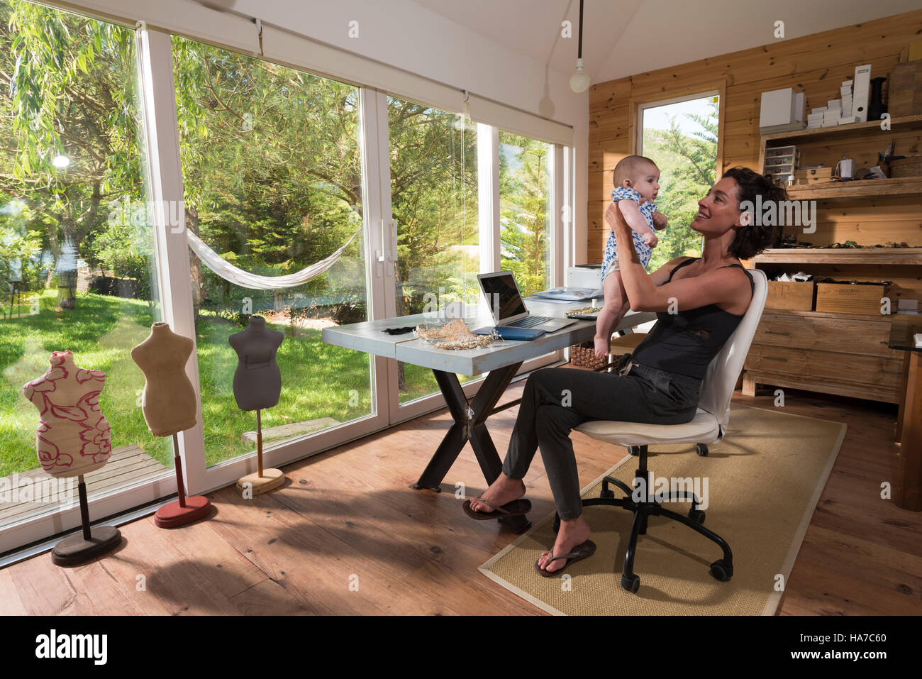 Self employed mother with her baby at home. Stock Photo