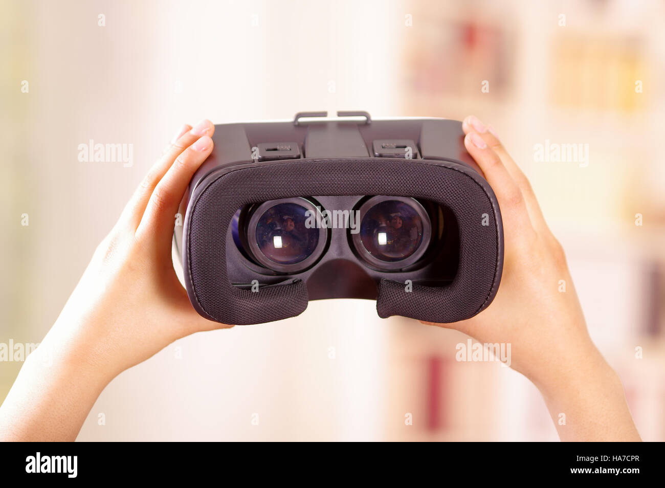 Young brunette woman holding up virtual reality goggles showing to camera, vr concept Stock Photo