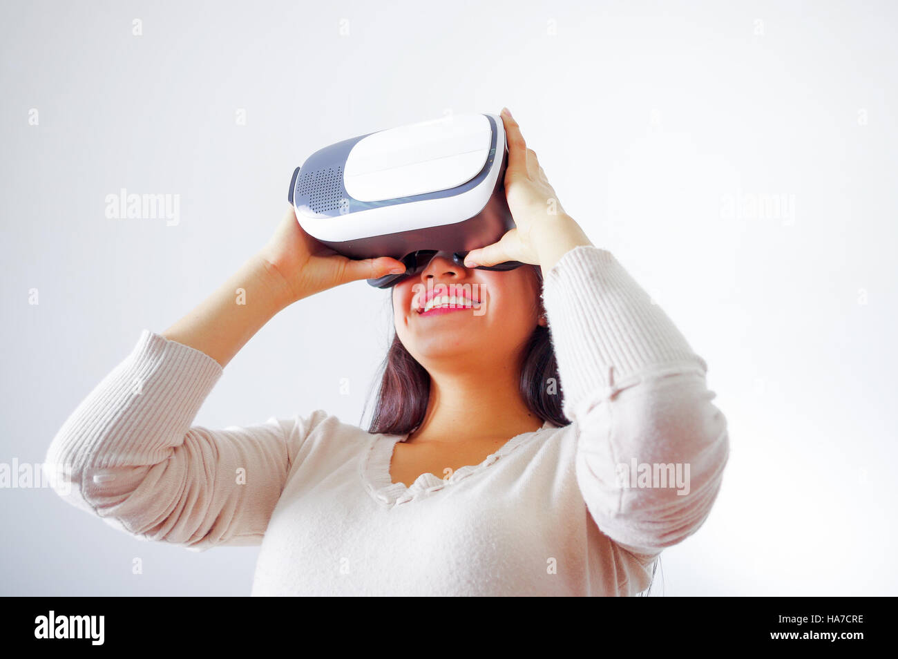 Young brunette woman wearing virtual reality goggles experiencing ...