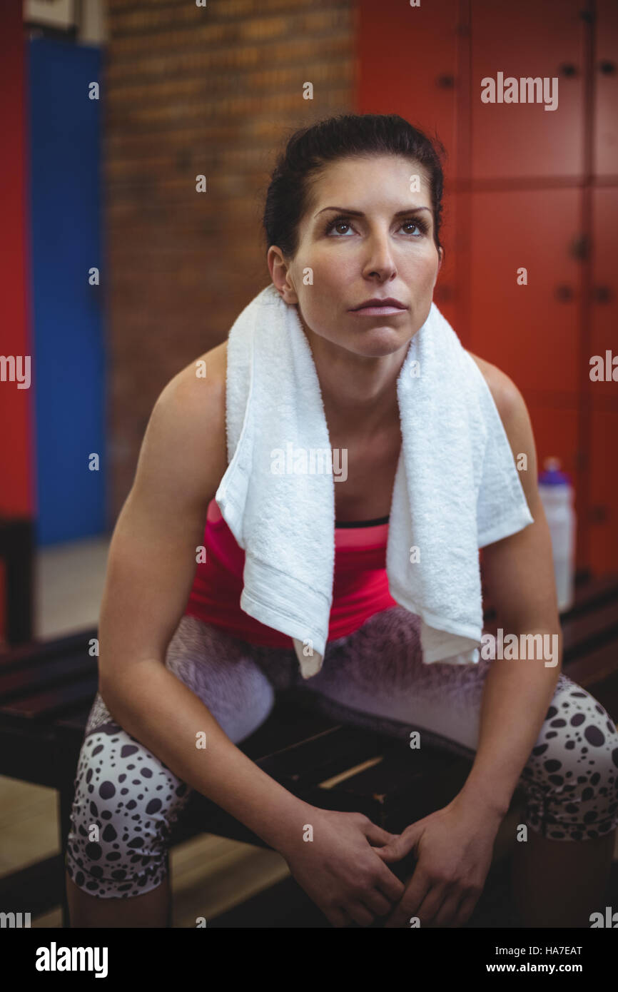 Woman sitting in gym locker room after workout Stock Photo