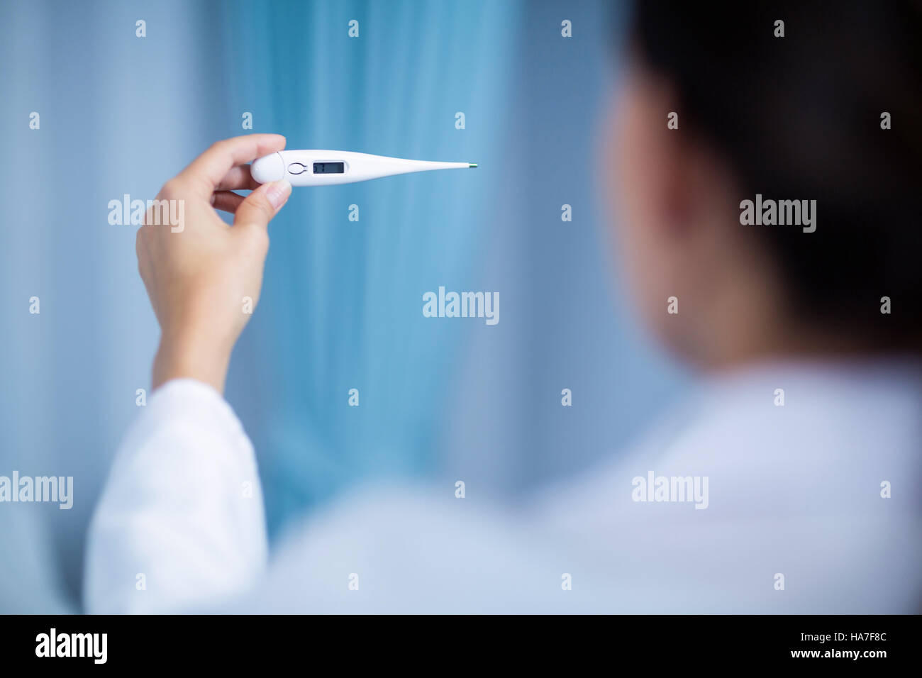 Female doctor checking fever from digital thermometer Stock Photo Alamy