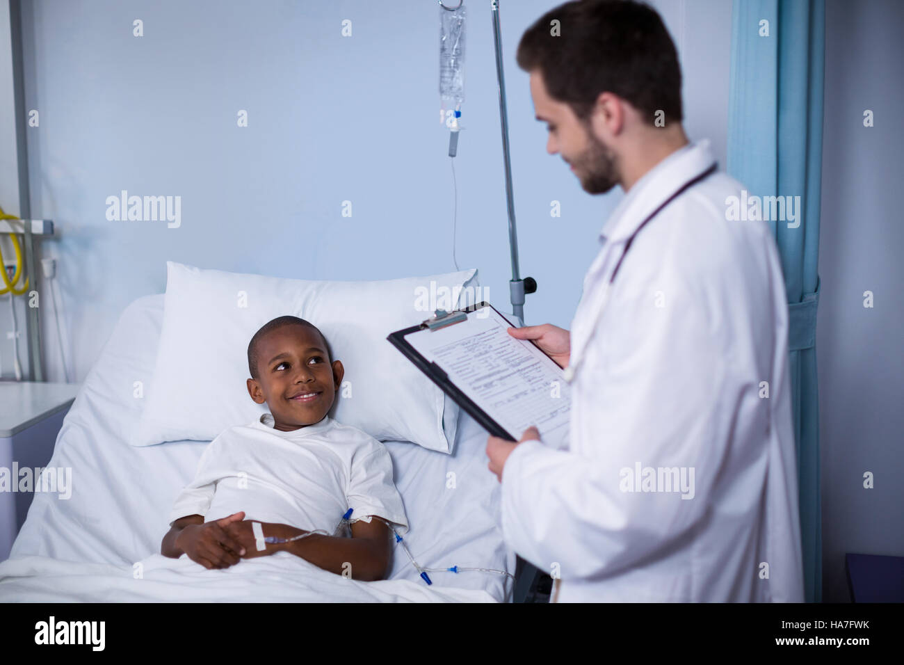Doctor reading report while patient sleeping on bed Stock Photo Alamy
