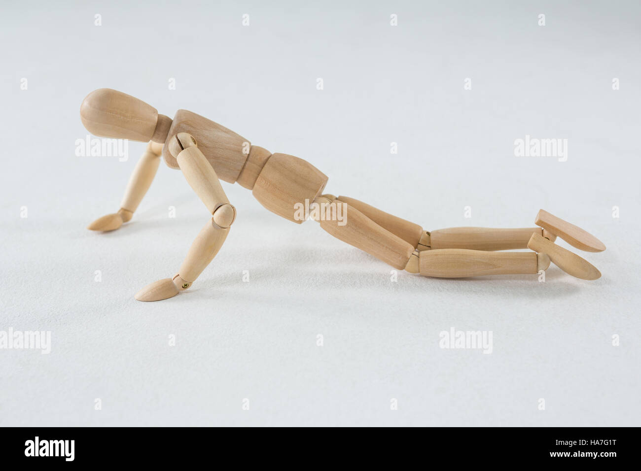 Wooden figurine doing push-up Stock Photo