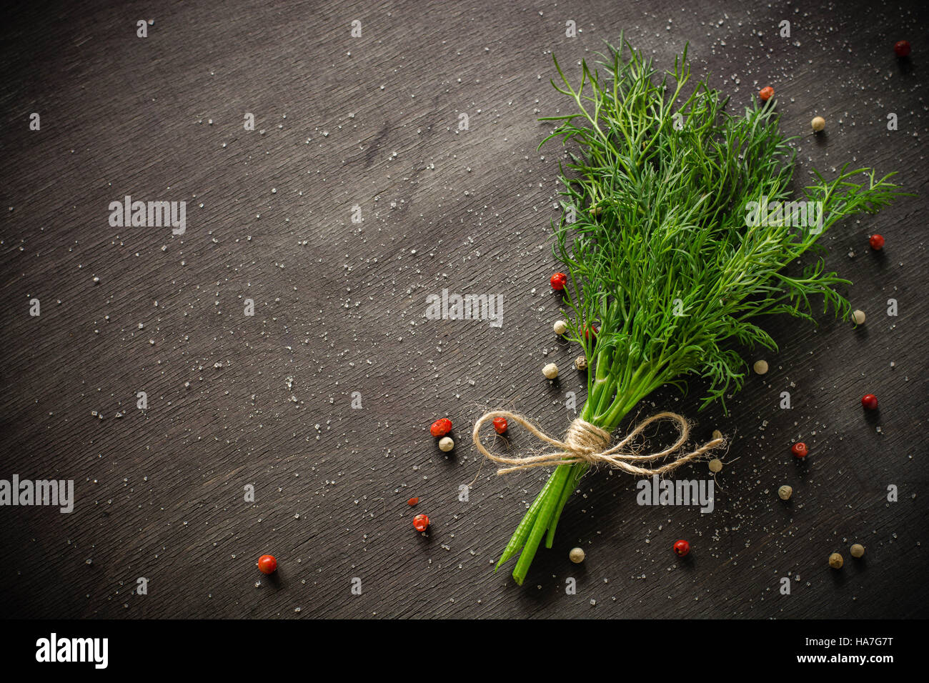 A bunch of fresh dill on dark wood background. Empty space for text ...