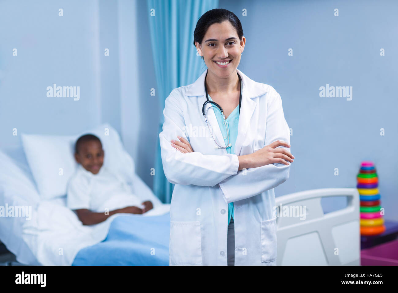 Portrait of smiling doctor standing with arms crossed Stock Photo - Alamy