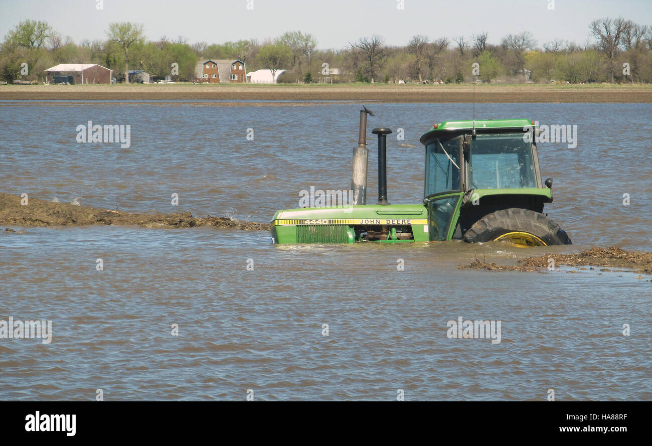 This photograph documents the impact of flooding in Pembina and Cavalier Counties, ND, affecting farmlands and roads. The image shows flooded fields, water damage, and the challenges faced by local farmers due to severe weather events. Stock Photo